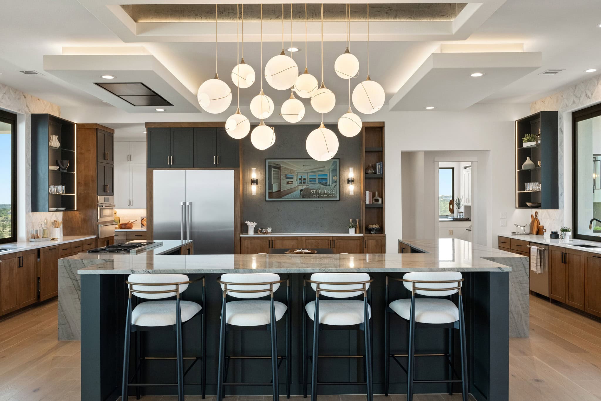 Interior kitchen view of Hilltop Haven, featuring a waterfall-edge stone island and Thermador appliances.